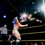 Ruotsalainen showpainija Aliss Ink hyppää Diana Strongin päälle showpainikehän päältä.